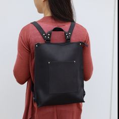 a woman wearing a black leather backpack