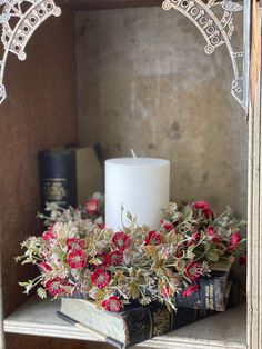 a candle and some books on a shelf