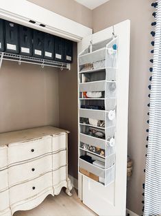 an organized closet is shown with drawers and hanging baskets on the door handle, along with other storage items