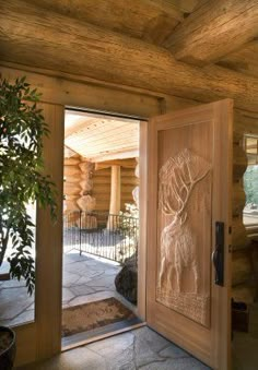 an open door leading into a log cabin with wood carvings on the doors and windows