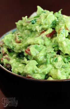 a bowl full of guacamole with bacon and lettuce on top