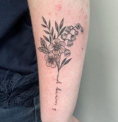 a woman's arm with flowers on it and the word love written in cursive writing