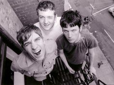 three young men standing on top of a stair case looking up at the camera man with his mouth open