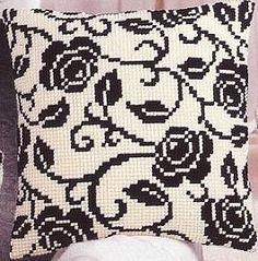 a black and white pillow sitting on top of a chair next to a stuffed animal