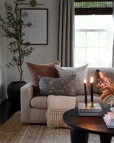 a living room filled with furniture and a coffee table in front of a large window