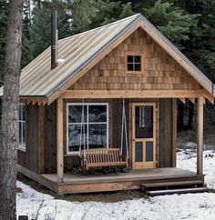 a small wooden cabin with a porch and swing