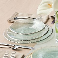 a table set for four with silverware and flowers