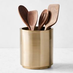 wooden utensils in a gold cup with spoons