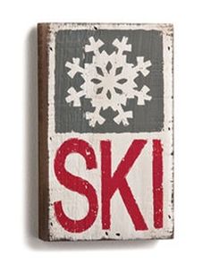 a wooden sign with snowflakes on it that says ski in red and white