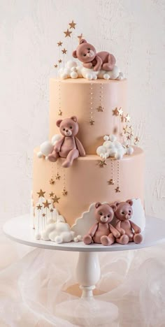 a three tiered cake with teddy bears on top and stars around the edges,