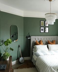 a bed room with a neatly made bed and green walls