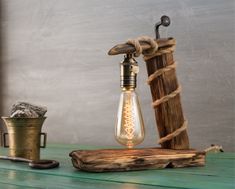 an old fashioned light bulb sitting on top of a wooden table next to a candle holder