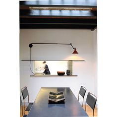 a dining room table and chairs with a book on it in front of a window