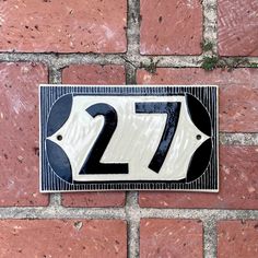 a house number sign on a brick wall