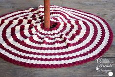 a red and white rug with a wooden stick sticking out of it