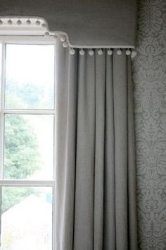 the curtains are hanging in front of an open window with white pom - poms