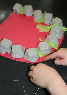 a child's hand is pointing at an object made out of ice cubes