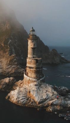 a light house sitting on top of a rock near the ocean