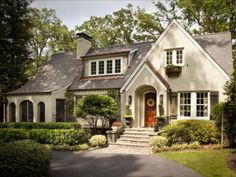 a white house surrounded by trees and bushes