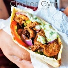 a chicken gyro sandwich is held in someone's hand with the words chicken gyro on it