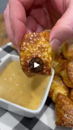 a person dipping some food into a bowl