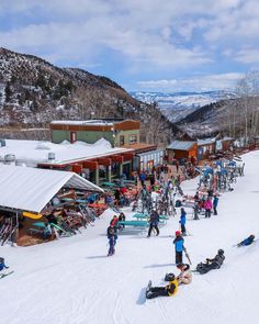 skiers and snowboarders at the bottom of a ski slope