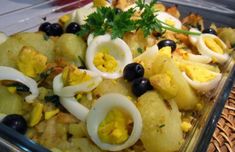 a glass dish filled with eggs, onions and black olives