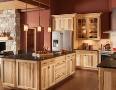 a large kitchen with wooden cabinets and black counter tops, along with an island in the middle