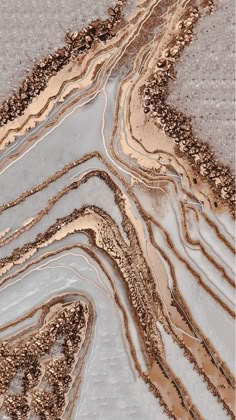 an aerial view of water and rocks in the desert, with brown lines on them