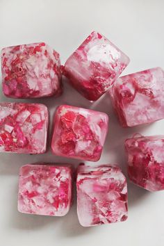 pink and white marble cubes on a white surface with red speckles in the middle