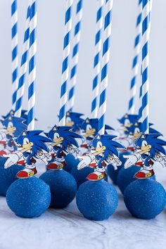 sonic the hedgehog birthday cake pops with blue and white striped straws on top