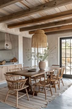 a dining room table with chairs and a vase on it