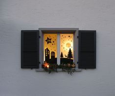 an open window with christmas decorations on the windowsill and night sky in the background