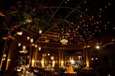 the inside of a building decorated with lights and chandeliers for a wedding reception