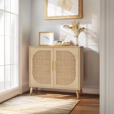 an empty room with a wicker cabinet and pictures on the wall next to it