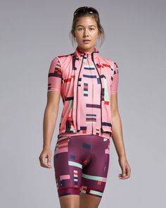 a woman is walking down the runway in tight shorts and a pink top with geometric designs on it