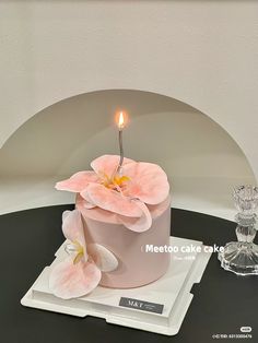 a cake with a candle and flowers on it