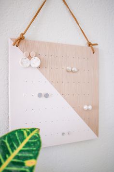 a wooden sign hanging on a wall with buttons and pins attached to the side of it