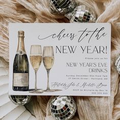 a new year's eve party card with two champagne glasses and disco ball decorations