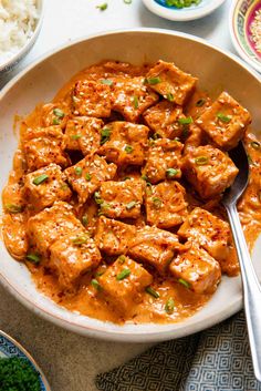 a bowl filled with tofu and rice on top of a table