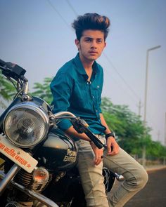 a young man sitting on top of a motorcycle