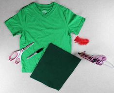 a green t - shirt, scissors and other crafting supplies