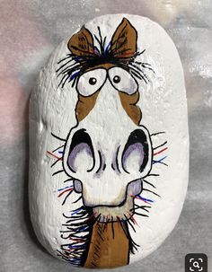 a painted rock with a horse's face on it