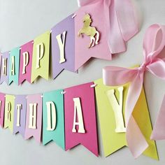 a happy birthday banner with pink and yellow ribbons