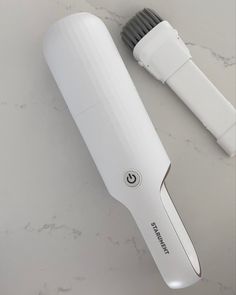 a white electric toothbrush sitting on top of a counter next to a hair dryer