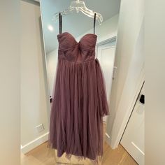 a dress hanging on a hanger in front of a door