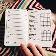 a person is holding an open notebook with numbers and times on it in front of a blanket