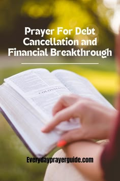 a person holding an open book with the title prayer for debt, cancellation and financial break through