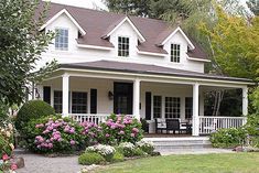 a white house with flowers in the front yard