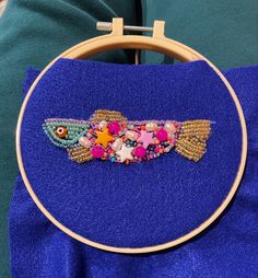 a hand embroidered fish on a blue towel